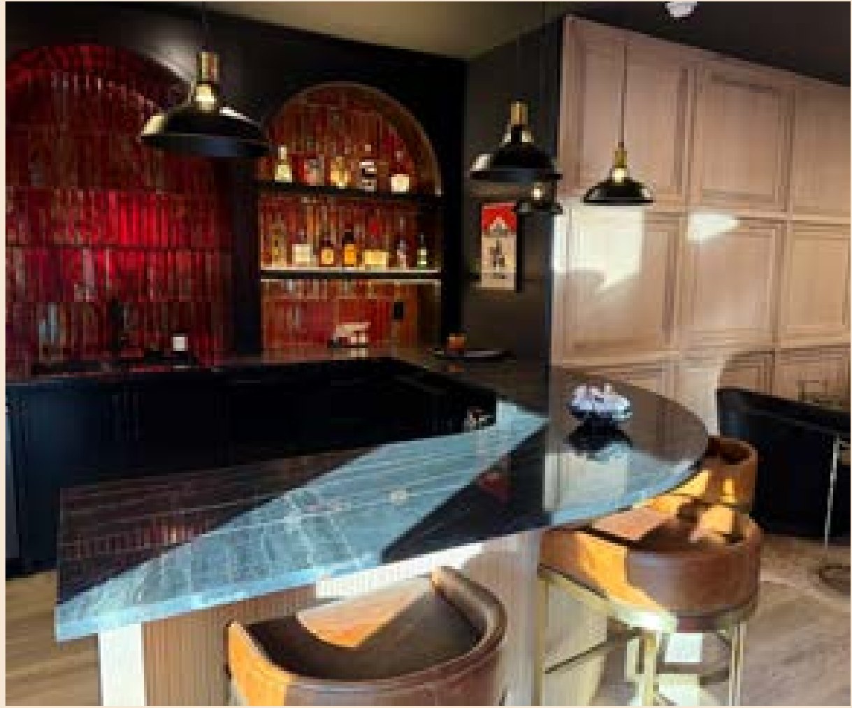 A finished home bar with red-lit niches and a marble counter